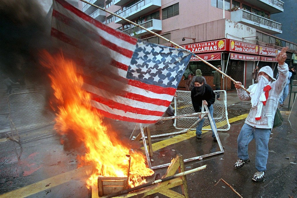 A man burns a US flag in the streets of Santiago on September 11, 1998, during demonstrations marking the 25th anniversary of the death of Chilean president Salvador Allende. The US has been criticised for its role the bloody military coup in 1973 that overthrew Allende and installed brutal dictator Augusto Pinochet. Photo: AFP