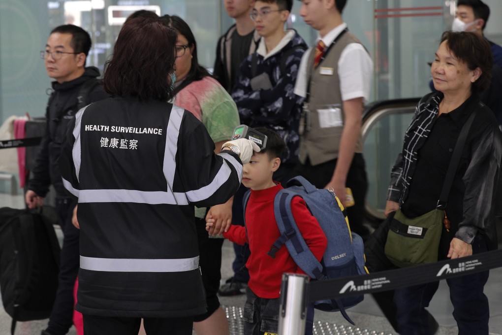 A health surveillance officer checks the temperature of passengers at Hong Kong International Airport. Photo: AP