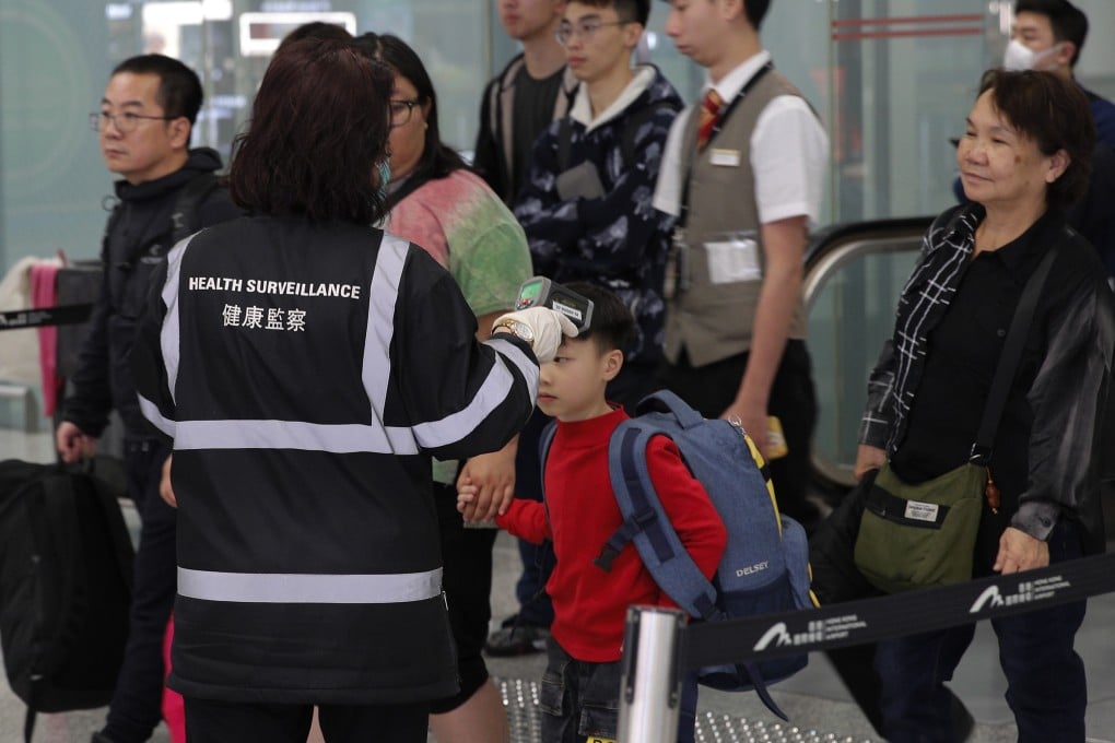 A health surveillance officer checks the temperature of passengers at Hong Kong International Airport. Photo: AP