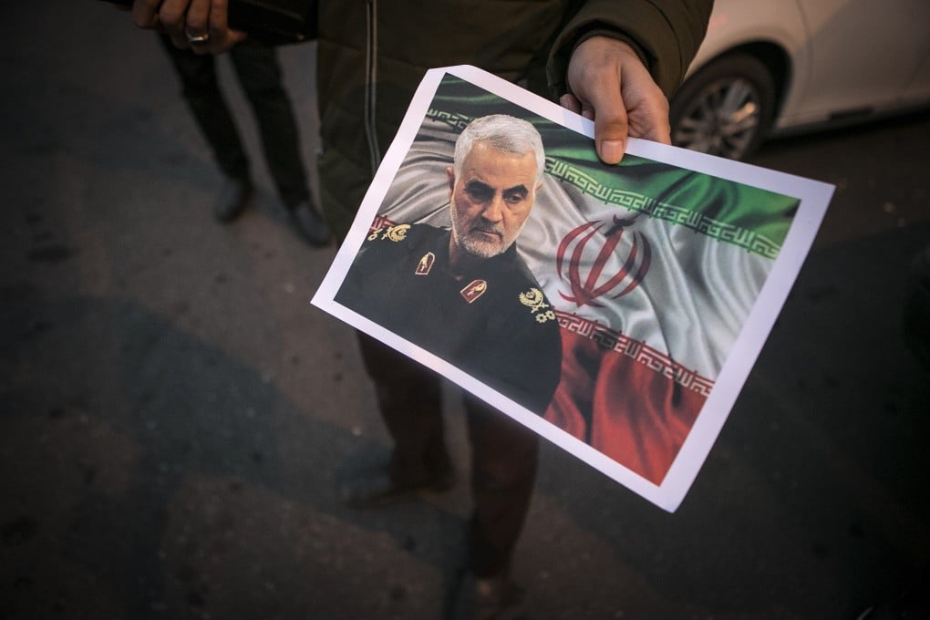 A man distributes a poster of top Iranian commander Qasem Soleimani during a protest in Tehran. Photo: Xinhua