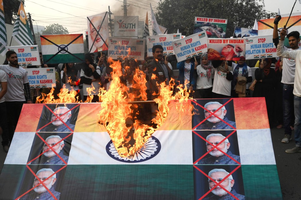 Activists of the Youth Forum for Kashmir burn an Indian flag with pictures of Indian Prime Minister Narendra Modi on Human Rights Day. Photo: AFP