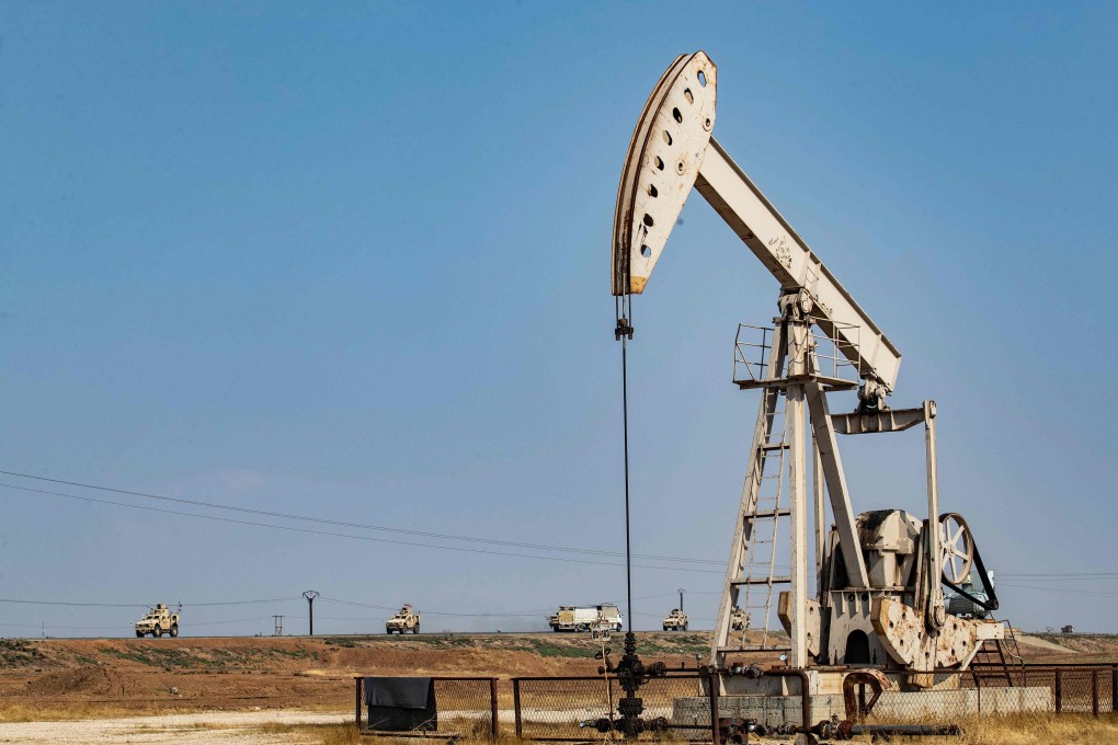 A convoy of US military vehicles, arriving from northern Iraq, drives past an oil pump jack in the countryside of Syria's northeastern city of Qamishli on October 26, 2019. Photo: AFP