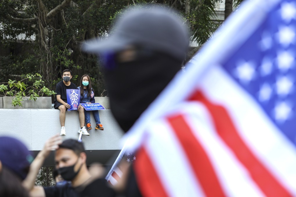 An anti-government protester carries a US flag during a rally outside the US consulate in Hong Kong. Photo: May Tse