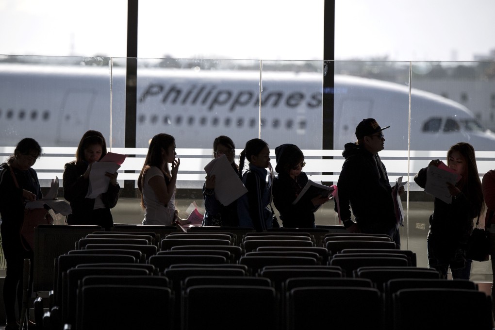 Filipino workers arrive at Manila International Airport after a flight from Kuwait. Photo: AFP