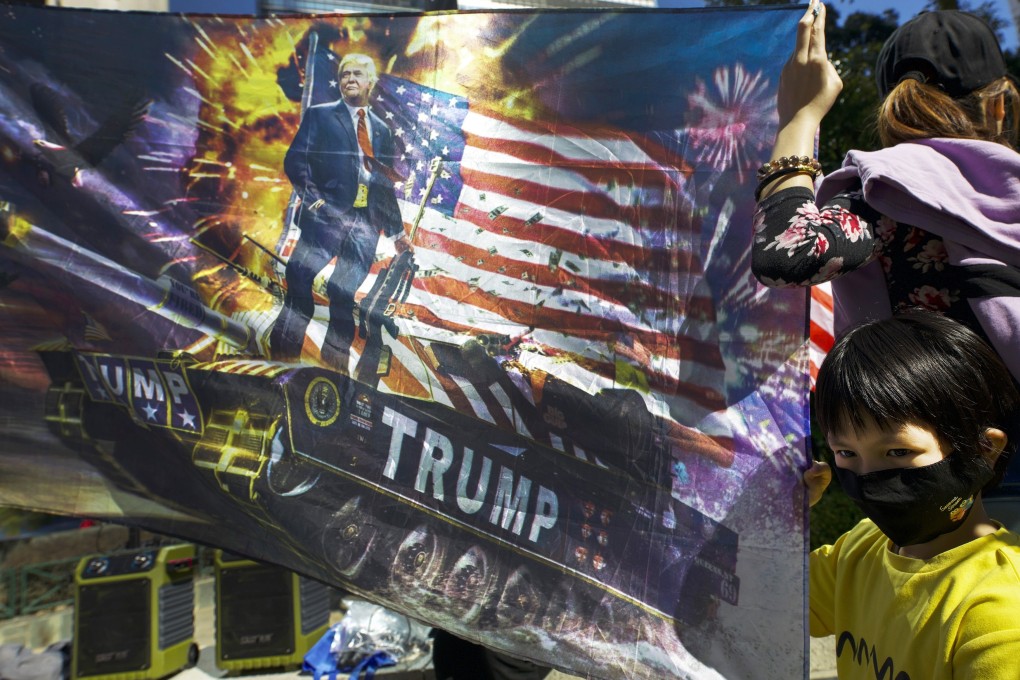 A child holds a poster depicting the US flag and US President Donald Trump, during an anti-government rally in Hong Kong on December 1 last year. In the US Human Rights and Democracy Act, the US calls on its allies in the Pacific to “promote human rights and democracy in Hong Kong”. Photo: AP