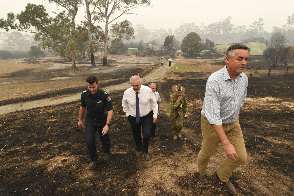 Australian Prime Minister Scott Morrison (centre) tours a farm that was ravaged by fire in Sarsfield, Victoria, on January 3. Photo: AP