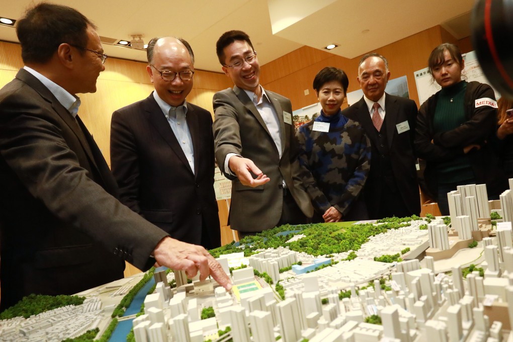 Frank Chan, Secretary for Transport and Housing, with SHKP executives and other officials inspecting a model of United Court, a planned transitional housing project. Photo: May Tse