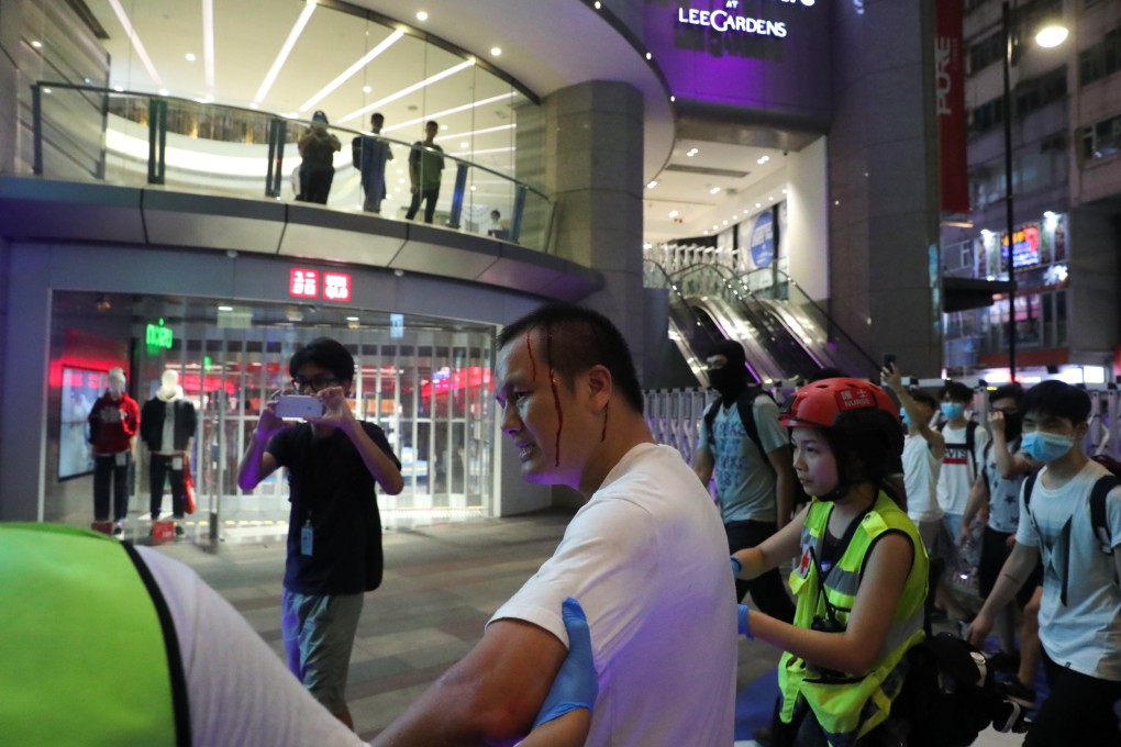 A man in white suffers a head wound near a Uniqlo outlet in Causeway Bay, Hong Kong during one of the anti-government protests in 2019. Photo: Sam Tsang
