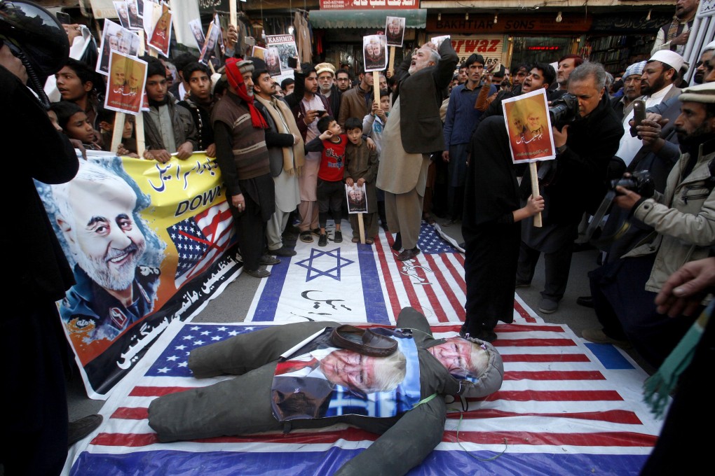 Pakistani Shiite Muslims stand on the representations of Israeli and US flags during a demonstration in Peshawar. Photo: AP