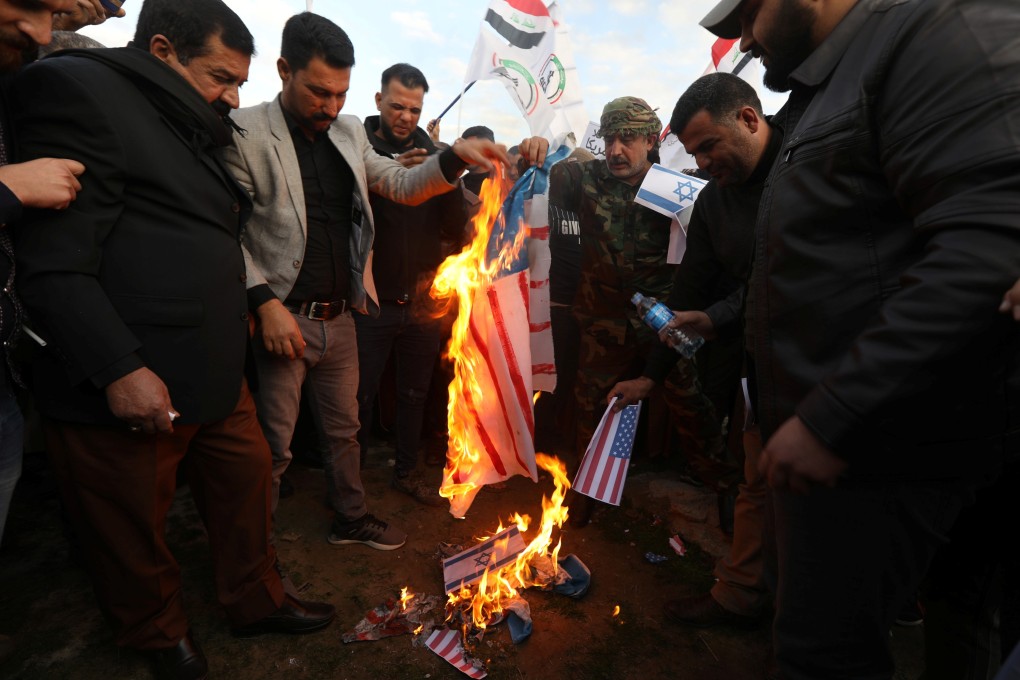 Iraqi people burn an Israeli and a US flag in a protest after an air strike at the headquarters of the Kataib Hezbollah militia group in Iraq. Photo: Reuters