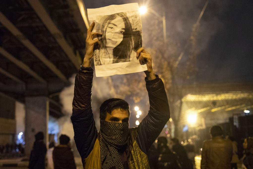 An Iranian man holds a picture of a victim of the Ukrainian plane crash during a demonstration in front of Tehran's Amir Kabir University on Saturday. Photo: AFP