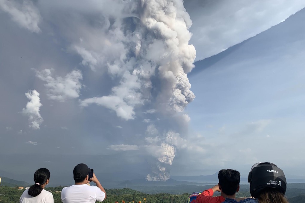 People take photos of a phreatic explosion from the Taal volcano, southwest of Manila in the Philippines. Photo: AFP