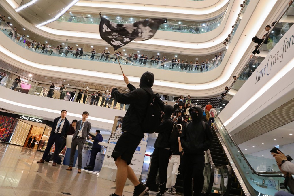 Black-clad, chanting protesters stage a demonstration at the Times Square shopping mall in Causeway Bay on Christmas Day. Photo: May Tse
