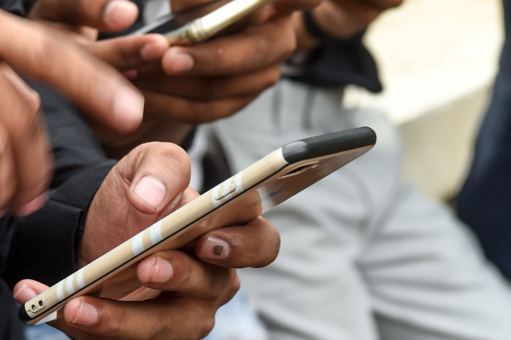In this photo taken on November 10, 2019, youngsters watch videos on the TikTok, the popular video-sharing app from ByteDance, on their smartphones in Mumbai. Photo: Agence France-Presse
