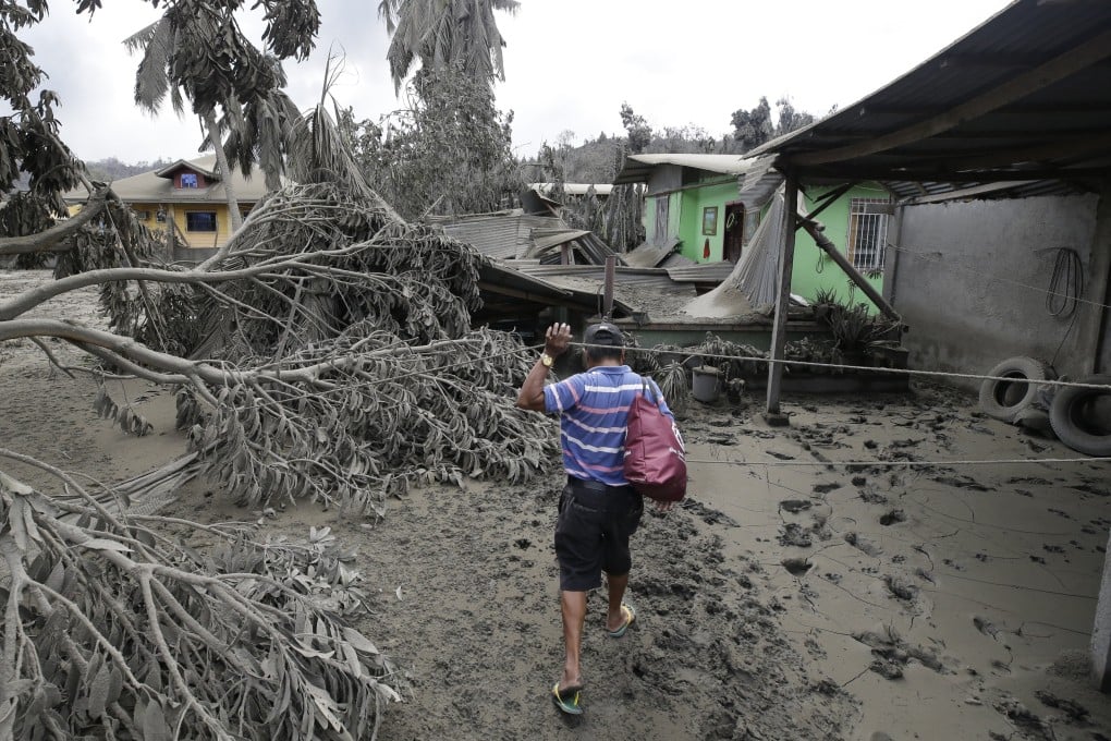 A resident checks his damaged house at Laurel, Batangas province on Tuesday. Photo: AP