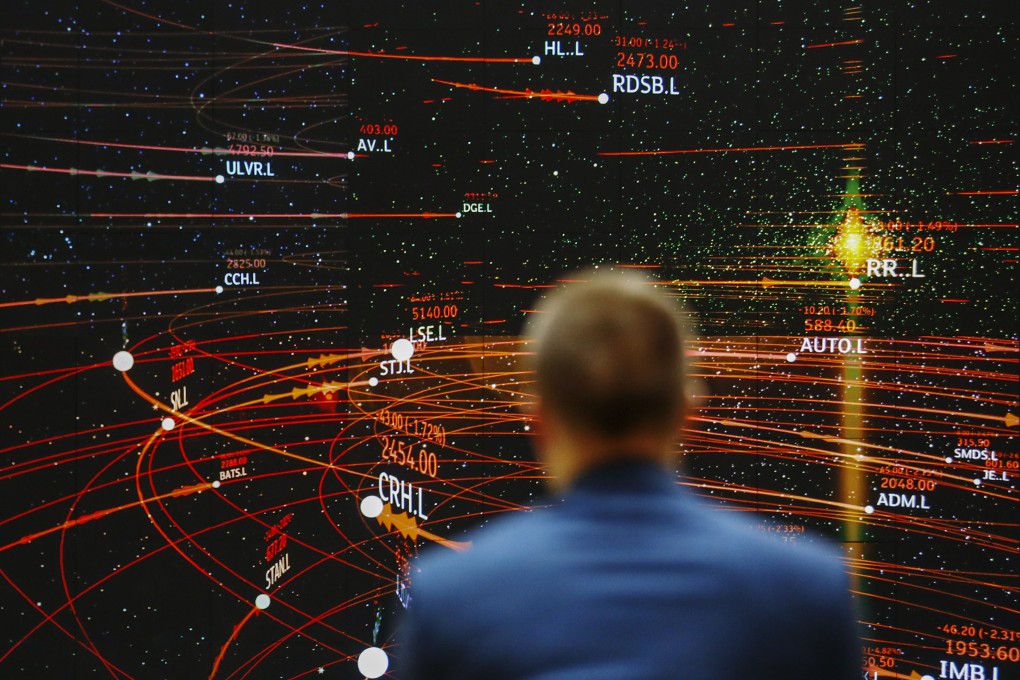 An employee views an FTSE share index board in the atrium of the London Stock Exchange Group’s offices in London. Photo: Bloomberg