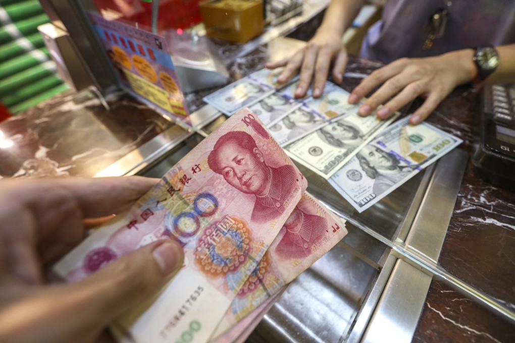 US dollar banknotes and Chinese one-hundred yuan banknotes are handled at a money exchange shop in Causeway Bay. Photo: Roy Issa
