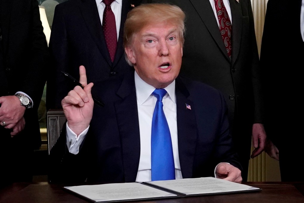 US President Donald Trump, surrounded by business leaders and administration officials, prepares to sign a memorandum on intellectual property tariffs on hi-tech goods from China at the White House in March 2018. Photo: Reuters