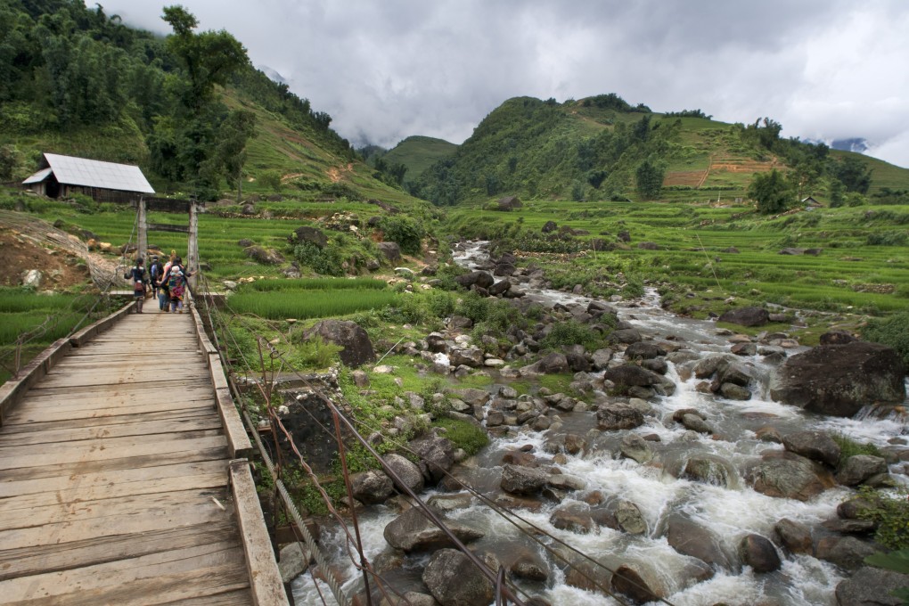 Hikers walk past rice terraces during a trek from Sapa to Lao Chai, in Vietnam. Photo: Getty Images