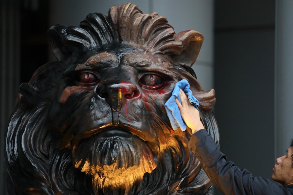 A worker cleans up one of the guardian lions at the HSBC headquarters, in Central, after it was vandalised during a protest on New Year’s Day. Photo: Nora Tam
