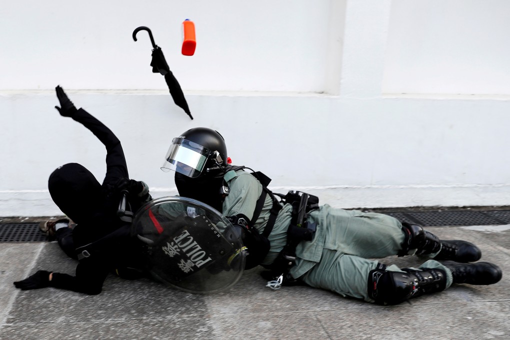 A riot police officer attempts to subdue a protester during an anti-government demonstration in Hong Kong. Photo: Reuters
