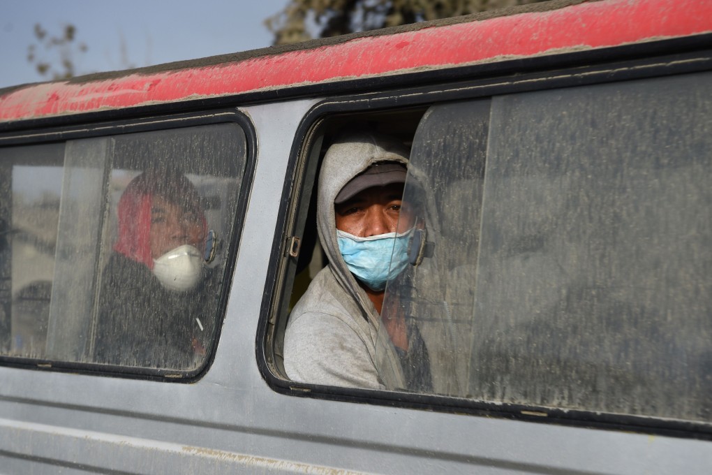 Mask-clad residents ride in a jeepney as they evacuate their homes in Laurel town, Batangas province, on January 15, 2020. Photo: AFP