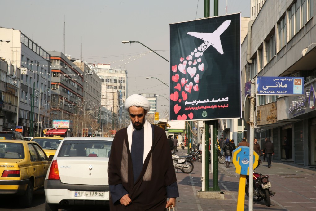 An Iranian cleric walks past a poster remembering the victims of a Ukrainian passenger jet accidentally shot down in Tehran on January 8. Photo: AFP