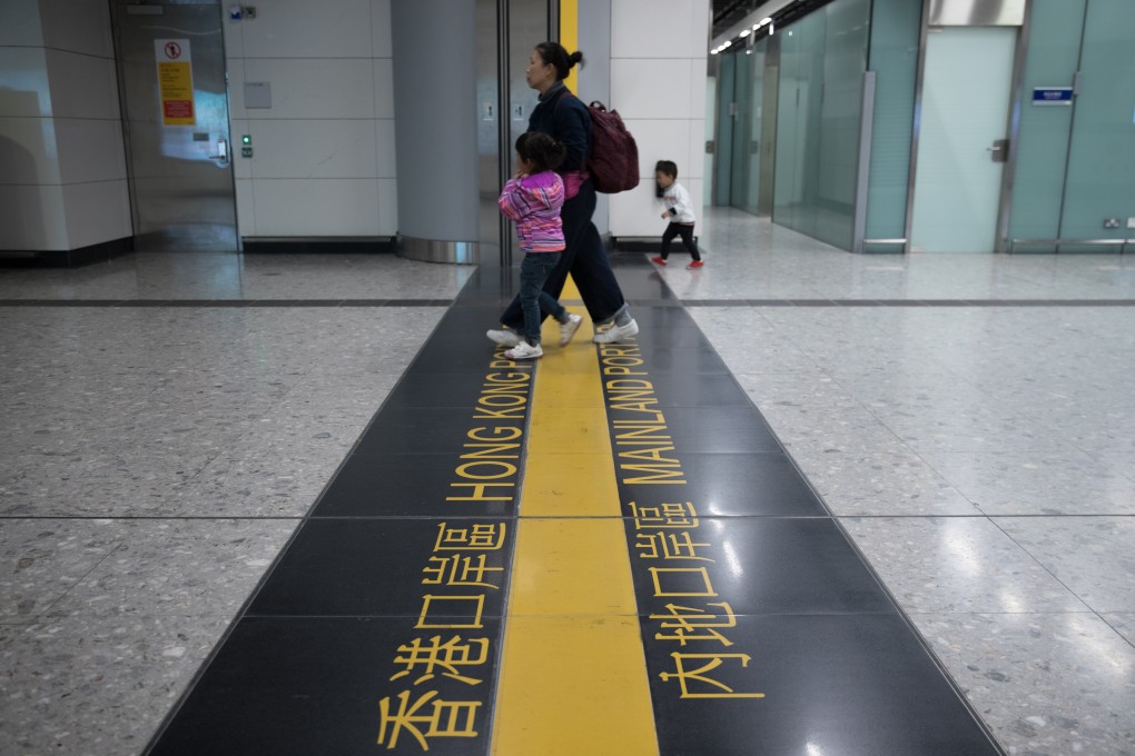 A woman and her children cross the line marking the boundary between mainland China and Hong Kong at the West Kowloon high-speed rail station. Photo: EPA-EFE