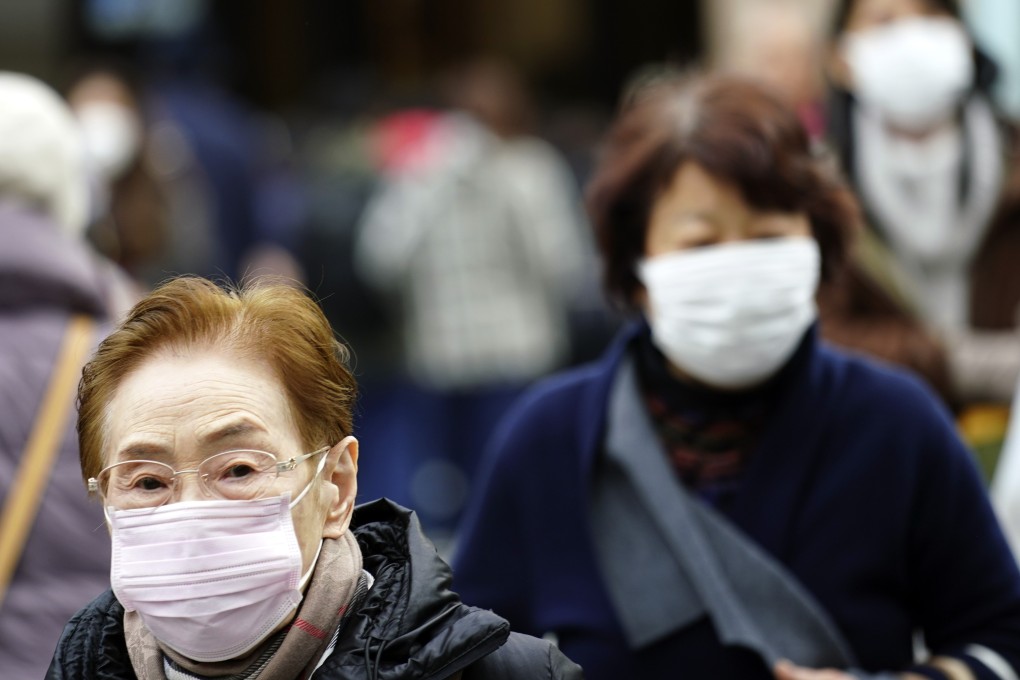 Japanese pedestrians wearing protective in one of Tokyo’s shopping districts. Photo: AP