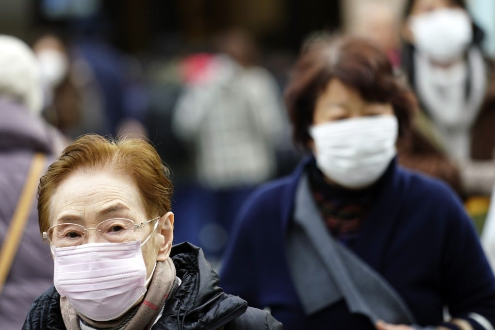Japanese pedestrians wearing protective in one of Tokyo’s shopping districts. Photo: AP