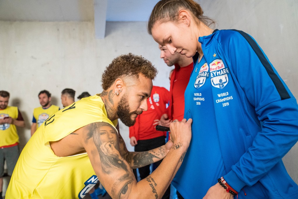 Brazilian star Neymar signs the shirt for a player from the winning women’s Neymar Jnr’s Five team who visited him in Paris. Photo: Red Bull