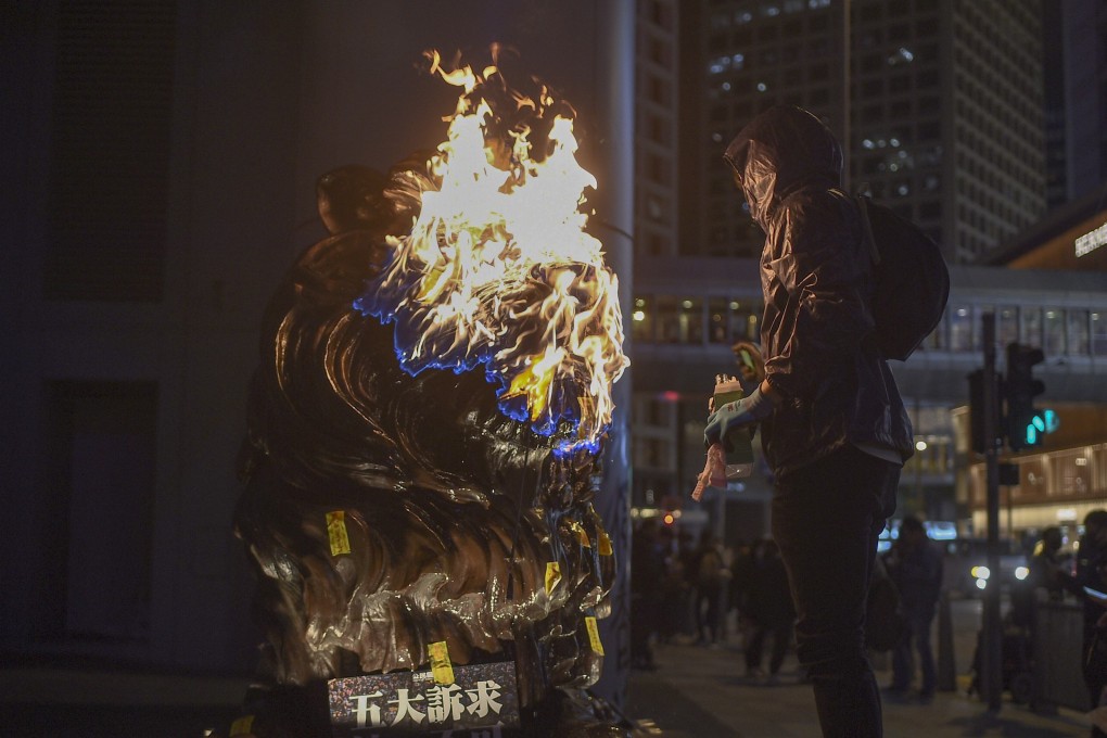 A protester sets fire to an HSBC lion statue outside the bank's headquarters in Central following a pro-democracy march in Hong Kong on January 1, 2020. Photo: AFP
