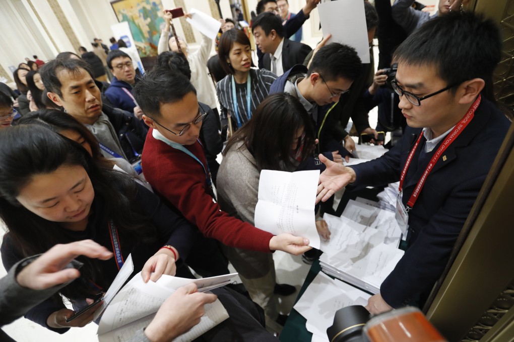 Reporters gather to get a document with GDP details ahead of a press conference by China’s State Council Information Office in Beijing on January 17. Photo: EPA-EFE