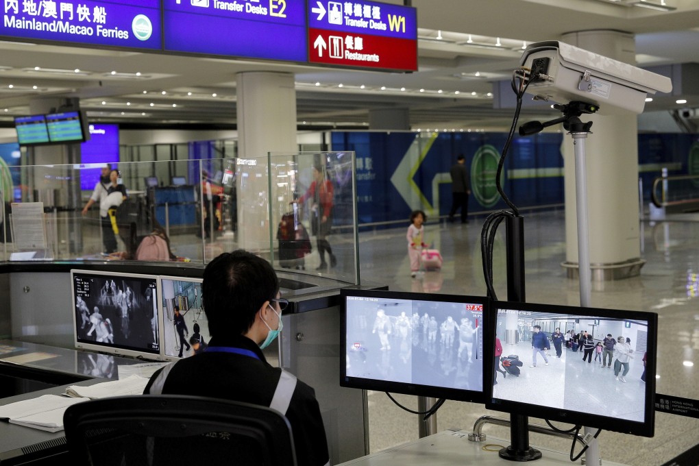 A health surveillance officer monitors passengers arriving at the Hong Kong International Airport on January 4. On Friday, US health officials said they will begin screening airline passengers from Wuhan at three US airports. Photo: AP