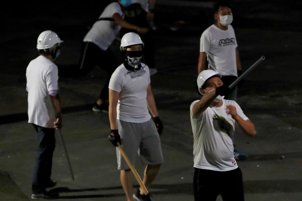 Men in white T-shirts armed with poles are seen in Yuen Long after attacking anti-extradition bill demonstrators at the MTR station in July. Photo: Reuters