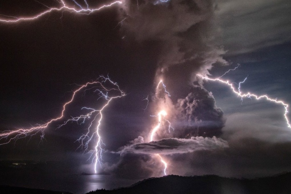 Lightning strikes as a column of ash surrounds the crater during the eruption. Photo: Handout