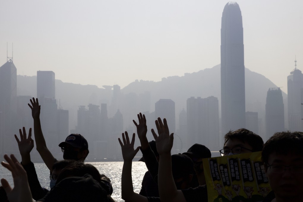 Anti-government protesters raise their hands to symbolise their five demands. Photo: AP