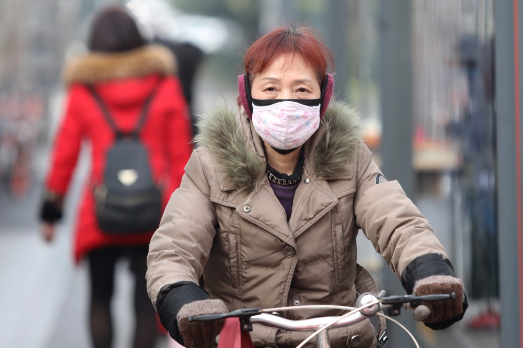 A cyclist wears a mask while riding past a bus station near the closed Huanan Seafood Wholesale Market in Wuhan on Monday. Photo: EPA-EFE