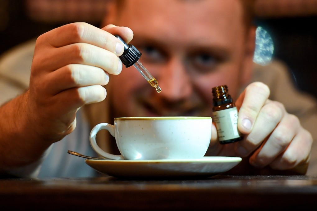 Nico Schack of Berlin’s first CBD cafe dribbles CBD oil into a cappuccino. Will this be one of the major foodie trends of 2020? Photo: dpa Picture-Alliance/AFP