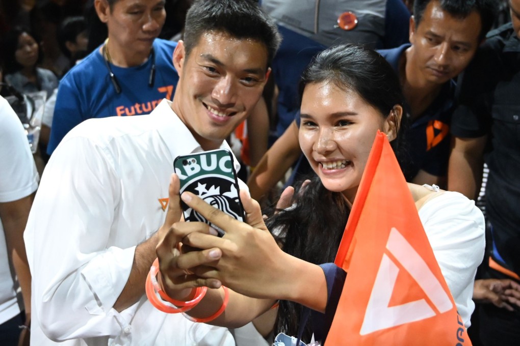 Thai Future Forward Party leader Thanathorn Juangroongruangkit (left) on the campaign trail. The orange flag bears the party’s triangular logo. Photo: AFP