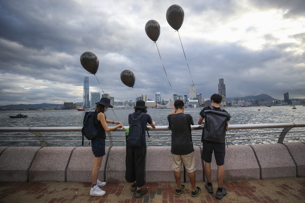 Protesters tie black balloons to the railing at the Wan Chai harbourfront during a protest against the extradition bill on July 1. The protests have continued for over seven months, with Hong Kong slipping into recession in October 2019. Photo: Winson Wong