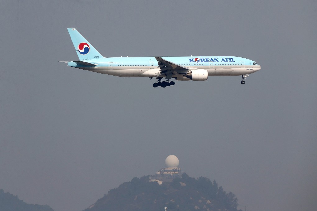 A Korean Air jet lands at a heavily polluted Hong Kong International Airport. Carbon offsetting schemes allow airlines to invest in environmental projects to compensate for the greenhouse gas emissions flights generate. Photo: Sam Tsang