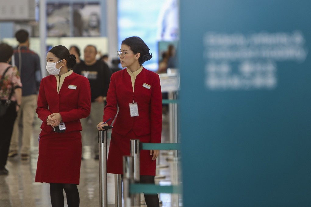 Cathay Pacific employees stand near the check-in desks at Hong Kong International Airport. Photo: Winson Wong
