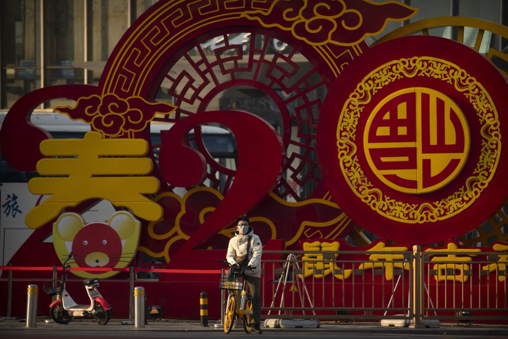 A bicyclist wears a face mask in front of a display for the upcoming Lunar New Year, in Beijing. Chinese health authorities urged people in the city of Wuhan to avoid crowds and public gatherings, as the new viral illness could spread further. Photo: AP Photo
