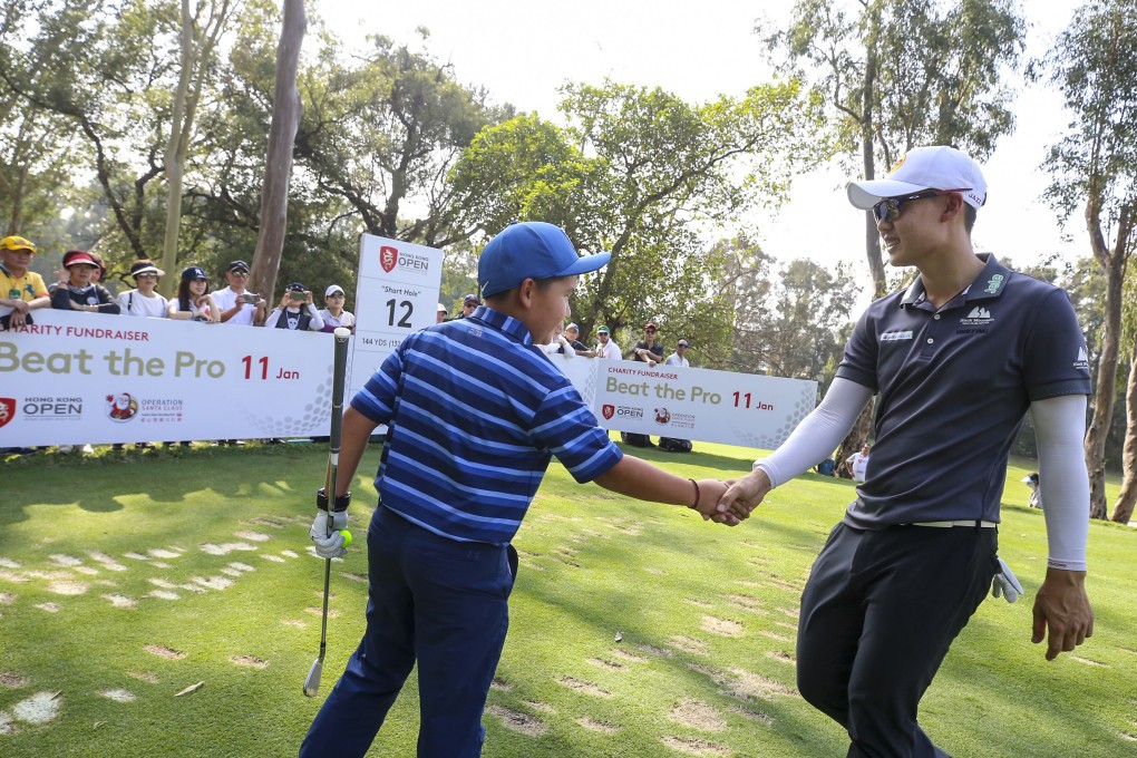 Jazz Janewattananond, of Thailand, shakes hands with a young golfer taking part in the Beat the Pro competition during the Hong Kong Open. Photo: Dickson Lee