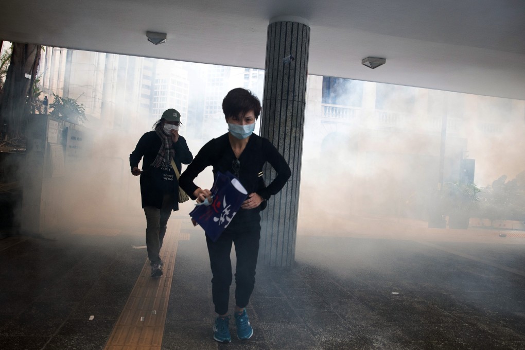 Demonstrators run as riot police deploy tear gas during a protest in Hong Kong’s Central district on Sunday. Photo: Bloomberg