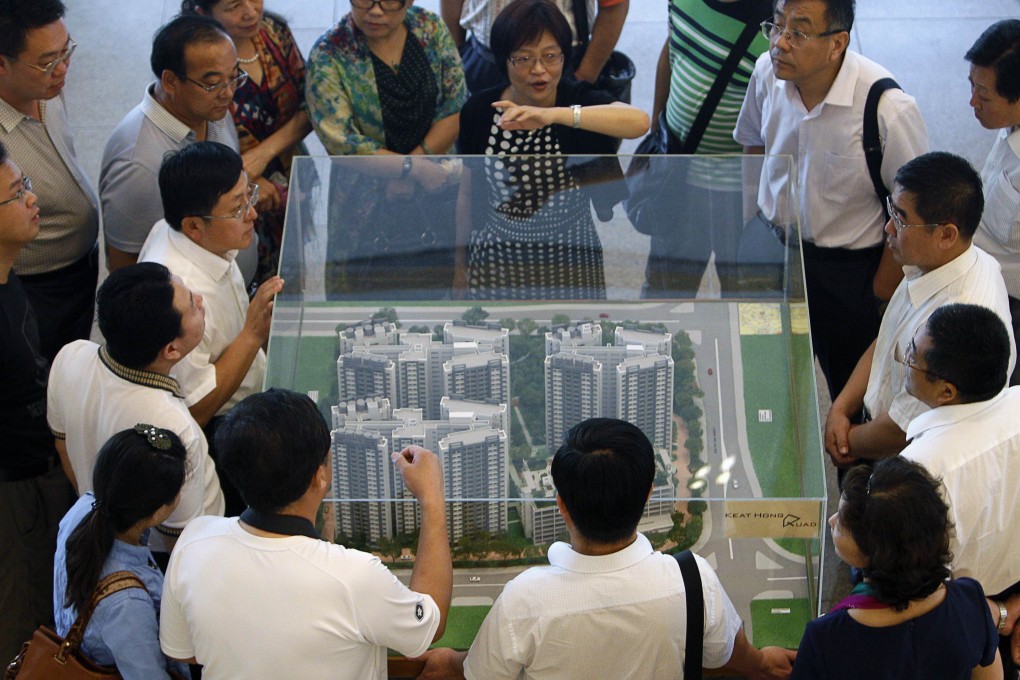 China visitors inspect a model of a public housing estate to be launched in Singapore. Photo: Reuters