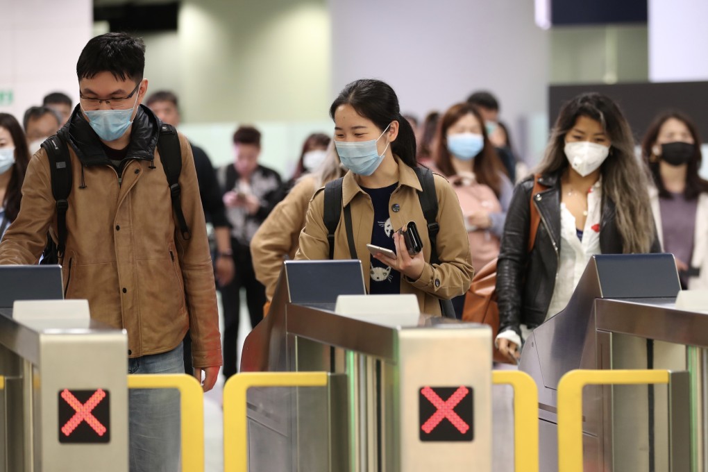 People wearing masks pass through exit gates in the arrival hall of West Kowloon railway station on January 22. Photo: Bloomberg