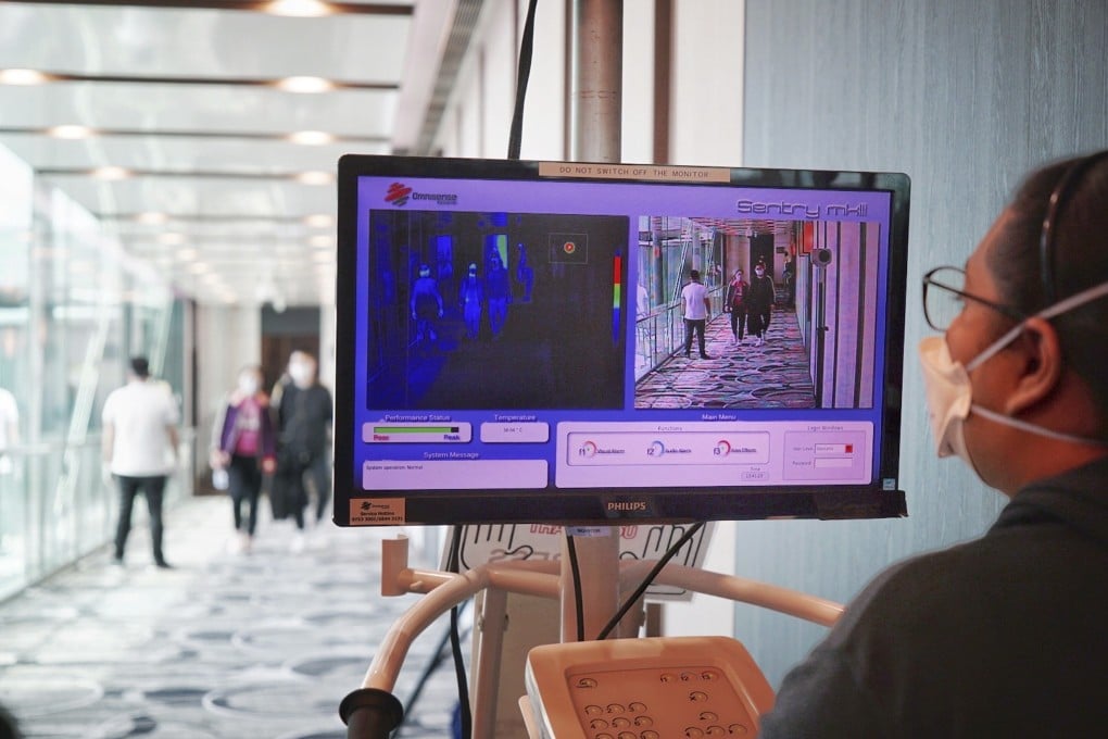 A staff member at Changi Airport screens the body temperatures of arriving passengers on January 22, 2020. Photo: EPA-EFE