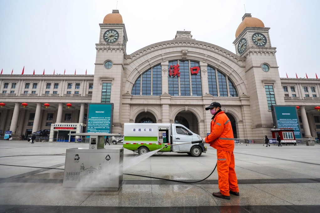 A cleaner washes a garbage bin outside the closed Hankou railway station in Wuhan, Hubei province. Wuhan has shut down public transport, including railway stations, airport, bus and subway services, in the city to control the spread of the new coronavirus. Photo: EPA-EFE